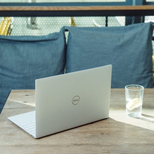 silver laptop on brown wooden table